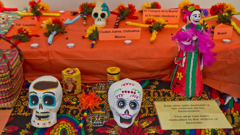 Crosses created by clients of WOAR in Philadelphia are placed on a smaller altar dedicated to victims of femicide in Central and Latin America. (Kimberly Paynter/WHYY)