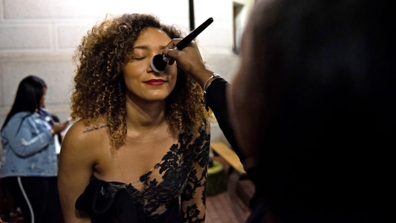 Maylynn Tamarez has her makeup retouched backstage at Philadelphia Fashion Week, held at Dilworth Park. (Kriston Jae Bethel for WHYY)