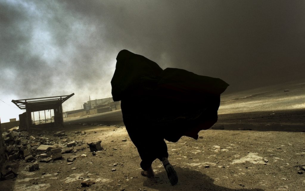 Of Love & War , 2018 An Iraqi woman walks through a plume of smoke rising from a massive fire at a liquid
gas factory as she searches for her husband in Basra, Iraq, May 2003.