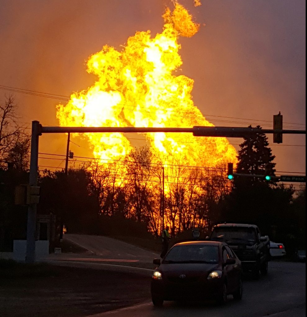 In this photo taken by Salem Township Supervisor Kerry Jobe, flames erupt during a natural gas explosion at a pipeline complex in Greensburg, Pa., Friday, April 29, 2016. The explosion, which burned one person, caused flames to shoot above nearby treetops in the largely rural Salem Township, about 30 miles east of Pittsburgh, and prompted authorities to evacuate businesses nearby. The cause of the blast wasn't immediately clear. (Kerry Jobe via AP)