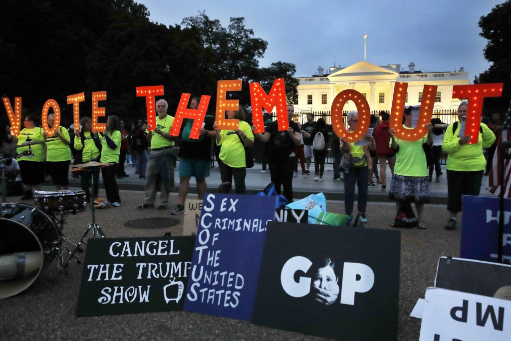 Supreme Court Kavanaugh People with the group Herndon Reston Indivisible hold up letters spelling
