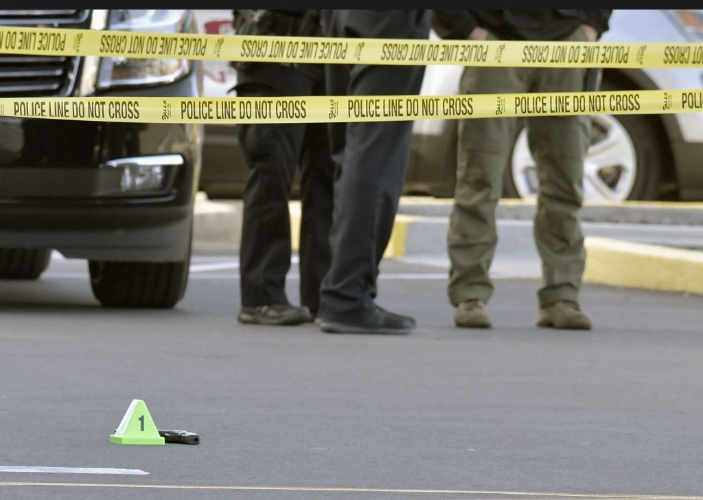 Grocery Shooting A gun lies on the ground inside a police barricade following a shooting at a Kroger grocery that left two people dead and a suspect in custody, Wednesday, Oct. 24, 2018, in Jeffersontown, Ky. A male suspect fatally shot a man and a woman at a Kroger grocery store on the outskirts of Louisville, Kentucky, and then exchanged fire with an armed bystander before fleeing the scene, police said. He was captured shortly afterward. (AP Photo/Timothy D. Easley)