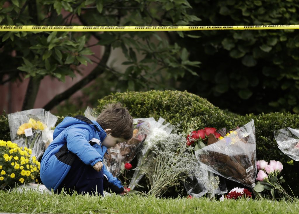 Shooting Synagogue Gideon Murphy places a flower at the Tree of Life Synagogue in Pittsburgh, Sunday, Oct. 28, 2018. Robert Bowers, the suspect in Saturday's mass shooting at the synagogue, expressed hatred of Jews during the rampage and told officers afterward that Jews were committing genocide and he wanted them all to die, according to charging documents made public Sunday. (AP Photo/Matt Rourke)