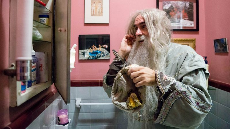 Walt Maguire adjusts his wig in his bathroom mirror. Maguire played the part of Dumbledore at the Chestnut Hill Harry Potter Festival for six years. (Rachel Wisniewski for WHYY)
