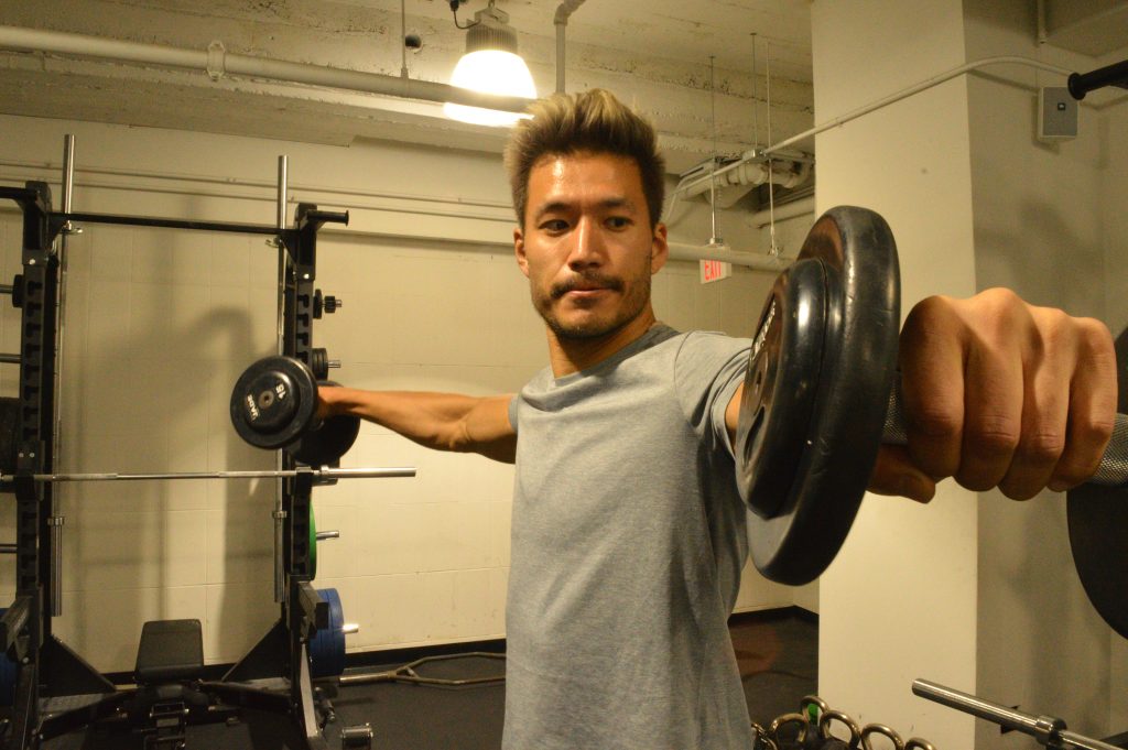 Kevin Kreider, a model and former bodybuilder, lifts weights at his local gym. Kreider says he quit pre-workout after becoming addicted. (Liz Tung/WHYY)