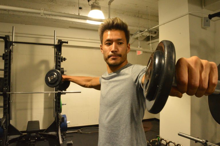 Kevin Kreider, a model and former bodybuilder, lifts weights at his local gym. Kreider says he quit pre-workout after becoming addicted. (Liz Tung/WHYY)