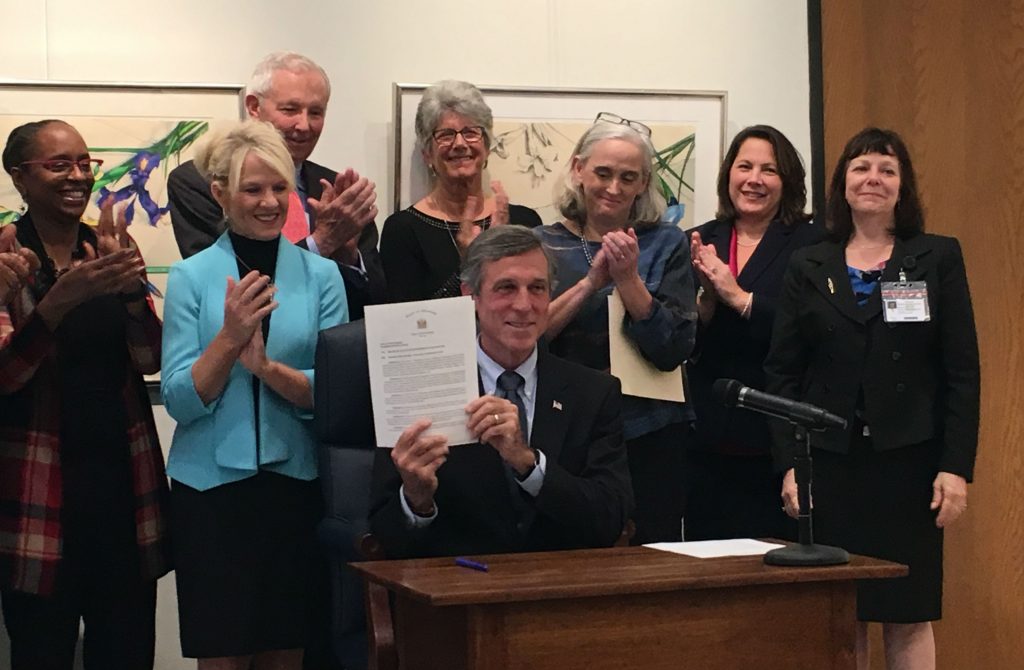 Trauma informed care Delaware Gov. John Carney holds up an executive order making Delaware a