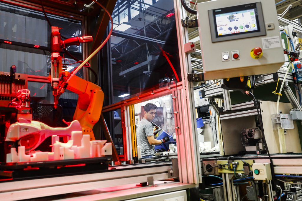 APTOPIX Future of Work Running the Robots In this 2017 photo, an assembly line laborer works alongside a collaborative robot, left, on a chainsaw production line. (AP Photo/John Minchillo)