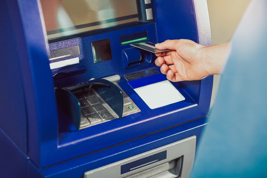 Man uses an ATM card inserted into the ATM machine for cash. (Big Stock photo)