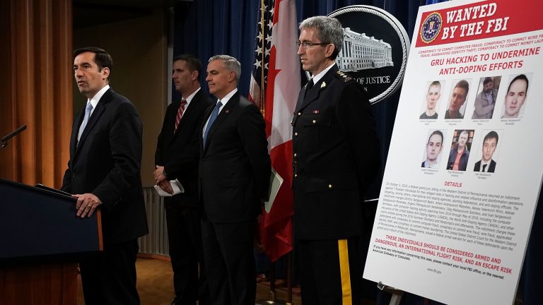 Assistant U.S. Attorney General for National Security John C. Demers, (left), speaks as U.S. Attorney for the Western District of Pennsylvania Scott W. Brady, 3rd from (left), FBI Deputy Assistant Director for Cyber Division Eric Welling, 2nd from (left), and Director General Mark Flynn, (right), for the Royal Canadian Mounted Police listen during a news conference to announce criminal charges Thursday.
(Alex Wong/Getty Images)