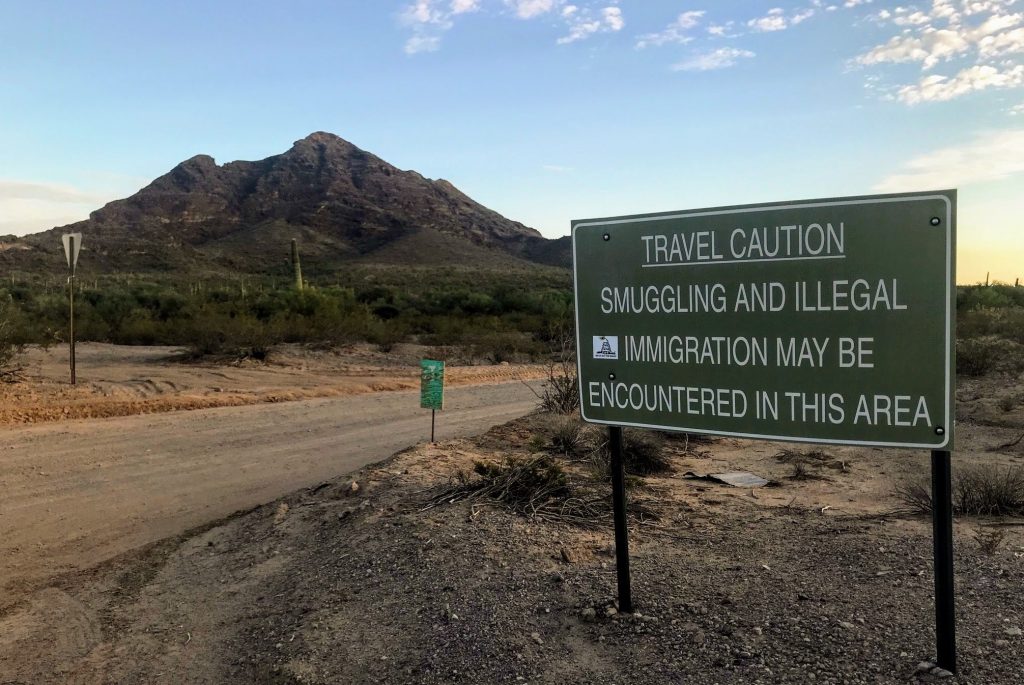 A sign outside Ajo, Ariz., warns hikers to keep an eye out for people who have unlawfully crossed the nearby border with Mexico. A sign outside Ajo, Ariz., warns hikers to keep an eye out for people who have unlawfully crossed the nearby border with Mexico. (Ryan Lucas/NPR)
