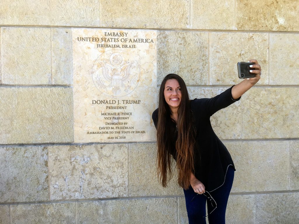 Beckah Shae, a Nashville-based singer-songwriter popular on Christian radio, snapped selfies with the dedication plaque outside the U.S. Embassy to Israel in Jerusalem. Beckah Shae, a Nashville-based singer-songwriter popular on Christian radio, snapped selfies with the dedication plaque outside the U.S. Embassy to Israel in Jerusalem. (Daniel Estrin/NPR)