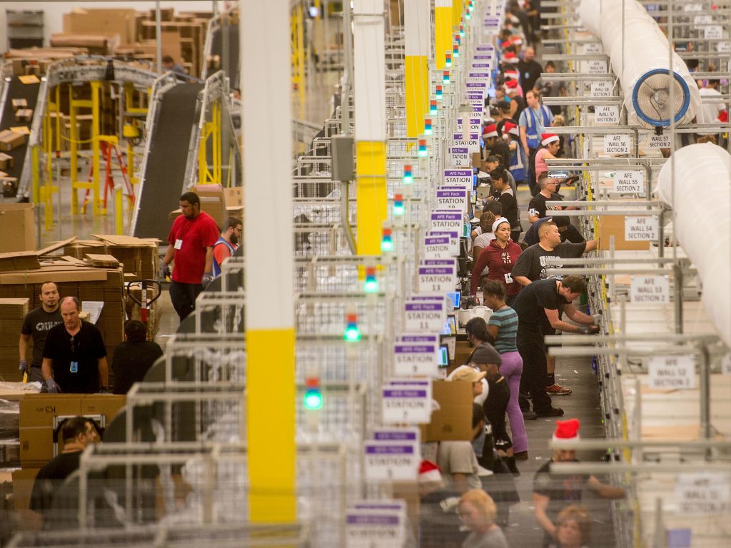 Amazon says it will pay all its U.S. workers at least $15. Here, workers prepare shipments at an Amazon Fulfillment Center in California during the early Christmas rush in 2014. Amazon says it will pay all its U.S. workers at least $15. Here, workers prepare shipments at an Amazon Fulfillment Center in California during the early Christmas rush in 2014