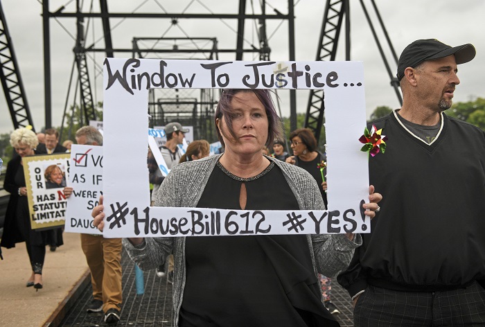 Clergy Abuse Civil Lawsuits Kelly Williams carries a sign voicing support for legislation that would change the statute of limitations for child sex crimes, during a march in Harrisburg, Pa., Monday, Sept. 24, 2018. At right is her husband Brent. A proposal to give victims of child sexual abuse a two-year window to sue over allegations that would otherwise be too old to pursue was overwhelmingly approved by the state House on Monday, as supporters cheered from the gallery. (Steve Mellon/Pittsburgh Post-Gazette via AP)