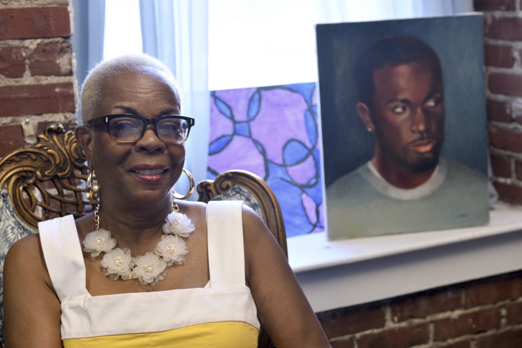 Participatory Defense Hub Dorothy Johnson-Speight, founder of Mothers in Charge, sitting before a painting of her murdered son, Khaliiq Jabbar Johnson. (Bastiaan Slabbers for Keystone Crossroads)