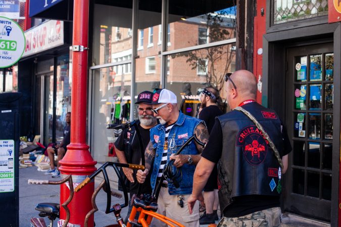 A few riders talk bikes outside of Tattooed Moms. (Brad Larrison for WHYY)