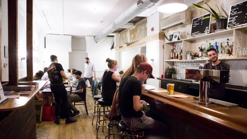 Patrons fill W/N W/N coffee bar on the evening of Oct. 10, 2018. While the bar boasts a wide variety of beverages, the food menu consists solely of pizza by resident chef Daniel Gutter, who cooks under the moniker of Pizza Gutt. (Rachel Wisniewski for WHYY)