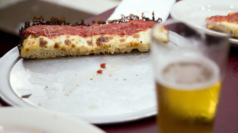 A nearly finished plain pizza sits on the table of Chris Calabrese and Nick Boucher (not pictured) at W/N W/N coffee bar on Oct. 10, 2018. (Rachel Wisniewski for WHYY)