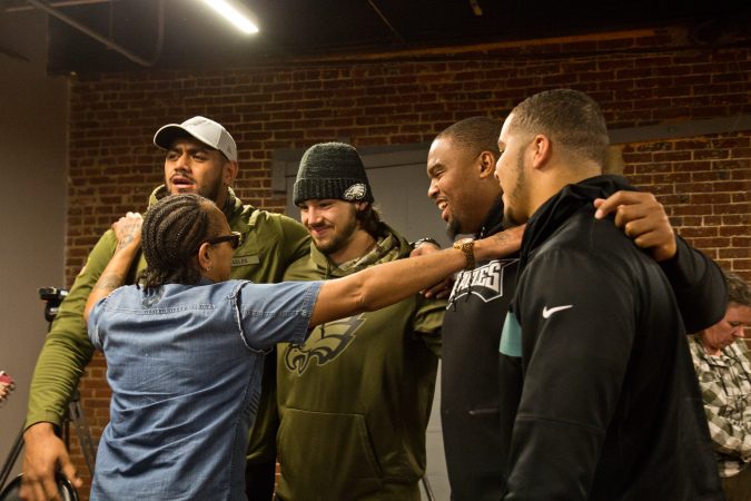 Faith Bartley with the Village of Arts and Humanities in Philadelphia meets members of the Philadelphia Eagles football team. (Kimberly Paynter/WHYY)