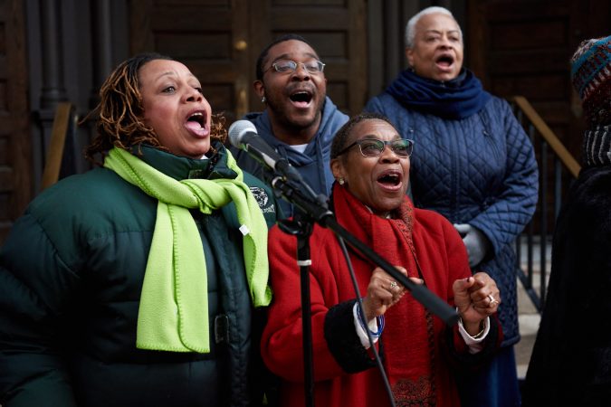 The Mother Bethel A.M.E. Church Choir lines up outside the church on the morning of Sunday, Nov. 18, 2018, and sings as participants of the Philadelphia Marathon run past. Some members include (from left) Beverly Renfrow, Michael Wyche, and Winnefred Rowell-Bullard. (Natalie Piserchio for WHYY)