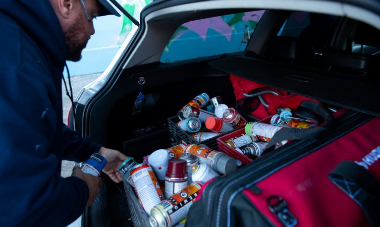 Spray paint used for a mural dedicated to Philadelphia
graffiti writer Karaz fills the trunk of a car on Saturday, November 3, 2018. (Kriston Jae Bethel for WHYY)