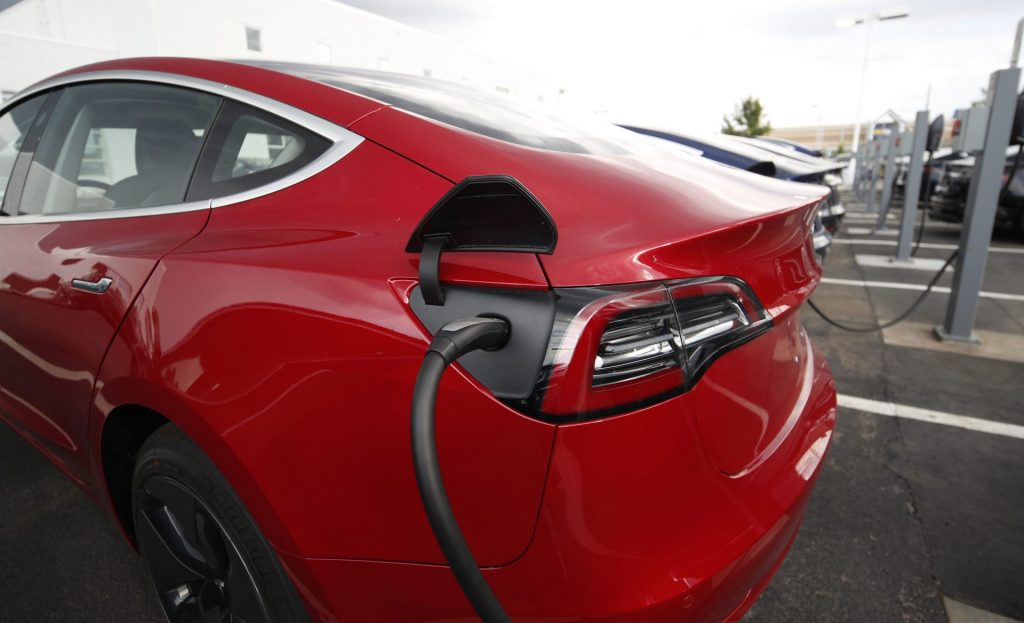 AP_18190129841640-1920×1168 In this Sunday, July 8, 2018, photograph, 2018 Model 3 sedans charge while on display outside a Tesla showroom in Littleton, Colo. (David Zalubowski/AP Photo)