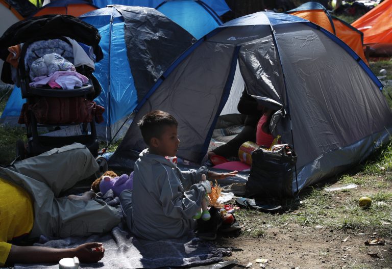 A migrant child sits outside a tent, taking shelter at the Jesus Martinez stadium in Mexico City, Tuesday, Nov. 6, 2018. Humanitarian aid converged around the stadium in Mexico City where thousands of Central American migrants winding their way toward the United States were resting Tuesday after an arduous trek that has taken them through three countries in three weeks. (Marco Ugarte/AP Photo)