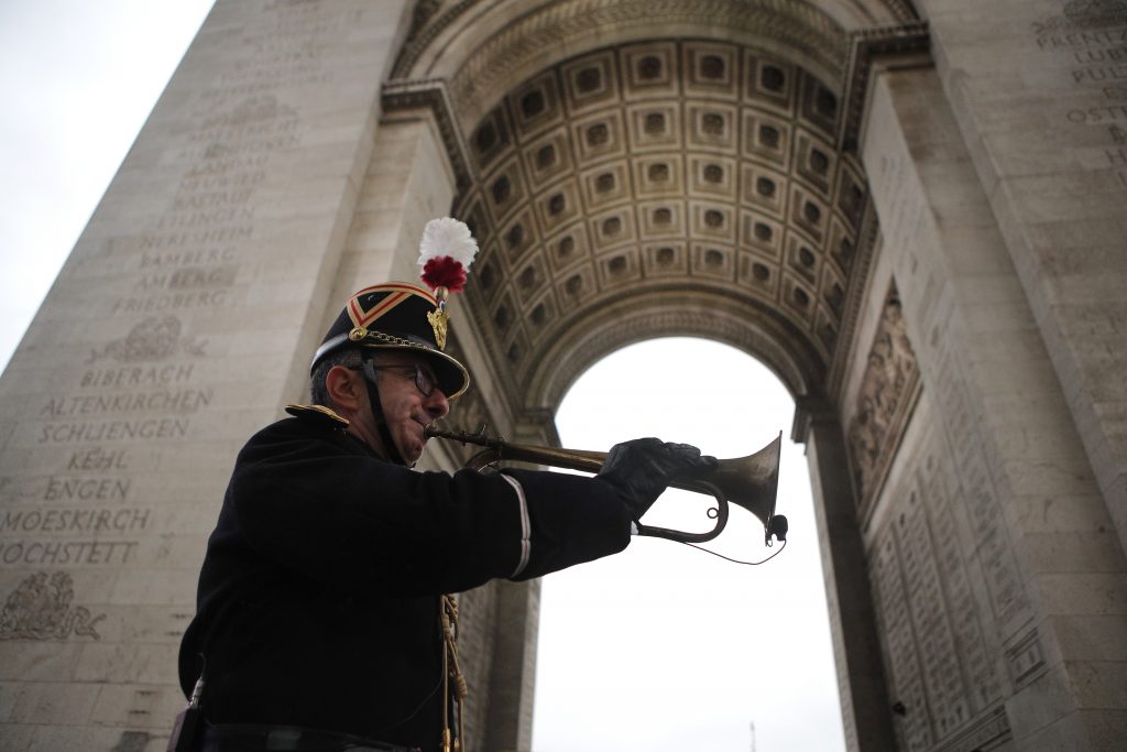 France WWI Centennial Military officer Garcia plays the original Armistice bugle from 1918 under the Arc de Triomphe Sunday, Nov. 11, 2018 in Paris. More than 60 heads of state and government are in France for the Armistice ceremonies at the Tomb of the Unknown Soldier in Paris on the 11th hour of the 11th day of the 11th month, exactly a century after the armistice. (AP Photo/Francois Mori, Pool)