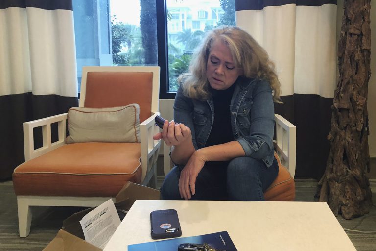 In this Nov. 1, 2018 photo, Polly Varnado looks at her daughter's Medtronic insulin pump in Destin, Fla. Medical device manufacturers and experts say insulin pumps are safe. But an AP investigation found that insulin pumps and their components are responsible for the highest number of malfunction, injury and death reports in the U.S. Food and Drug Administration’s medical device database.  (Holbrook Mohr/AP Photo)