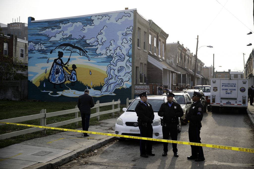 Four Shot in Basement Police gather at the scene of a fatal shooting in the center row home in Philadelphia, Monday, Nov. 19, 2018. Police say two men and two women have been found shot and killed in a basement in Philadelphia. (AP Photo/Matt Rourke)