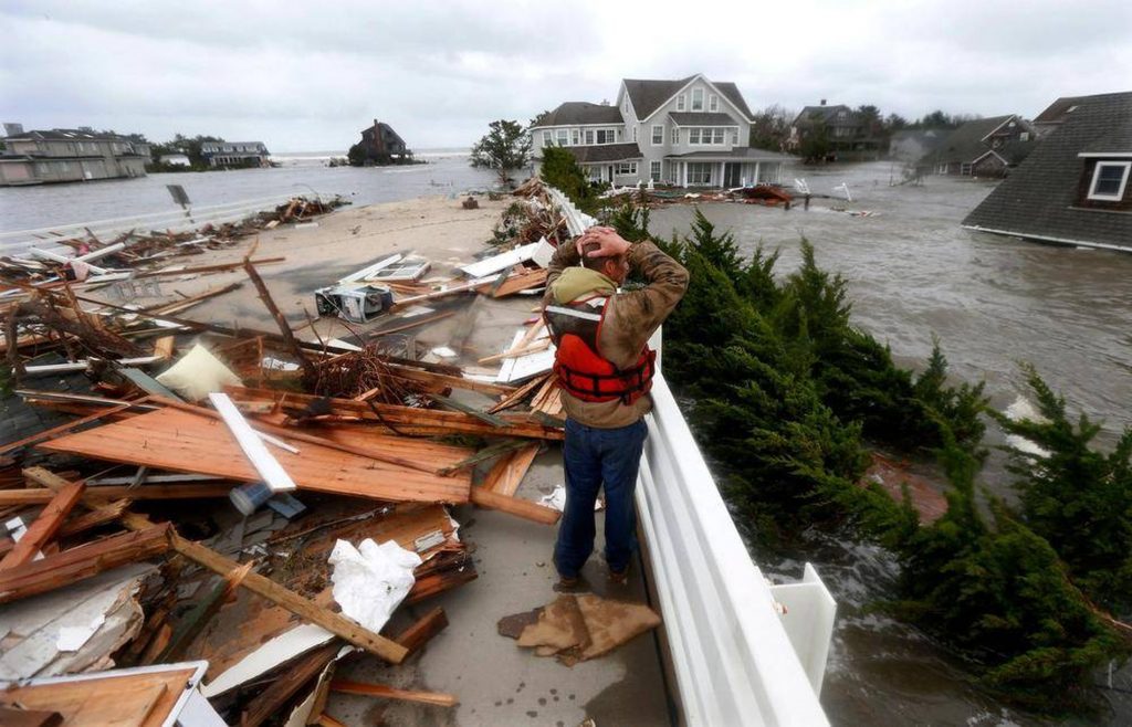 B6SCTD3VYFHGPJYIBJGTAZQPZ4 Brian Hajeski, 41, of Brick, N.J., reacts as he looks at debris of a home that washed up on to the Mantoloking Bridge the morning after superstorm Sandy rolled through in Mantoloking, N.J., Oct. 30, 2012. (Julio Cortez/AP Photo)