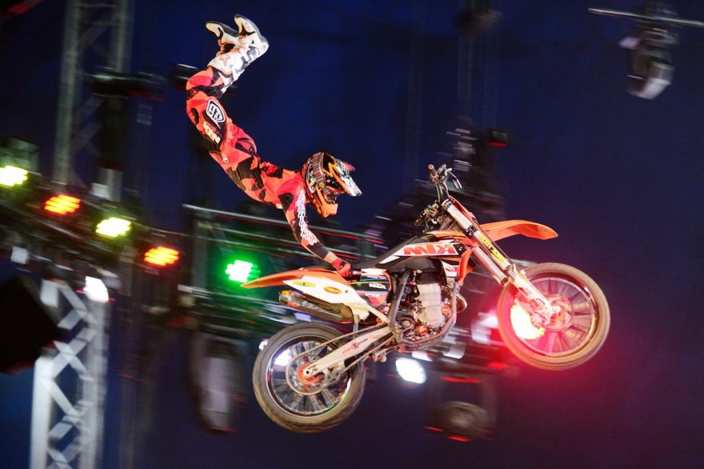 D6N_3288_edited A performer on a motorbike kicks their feet in the air