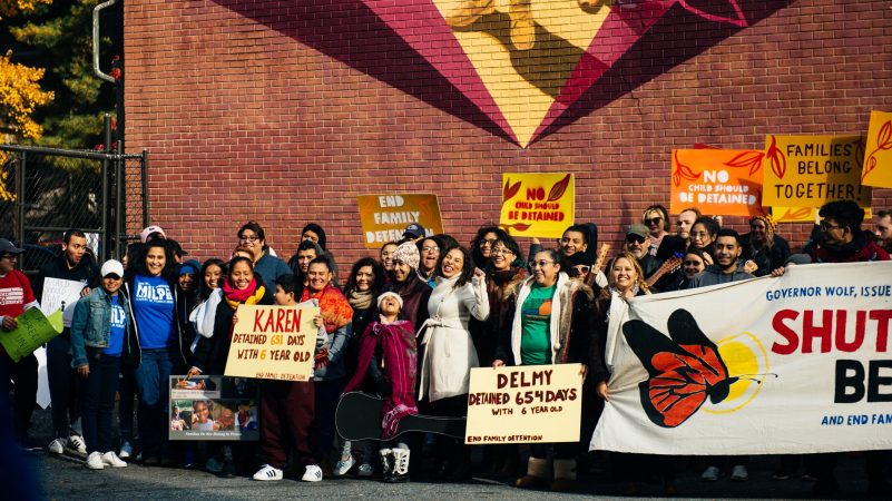 Michelle Angela Ortiz celebrates the dedication of her mural to the immigrant community in Allison Hill. (Dani Fresh for WHYY)