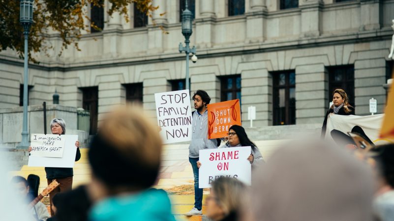 Antonio Morales holds signs in support of shutting down Berks County Residential Center. (Dani Fresh for WHYY)