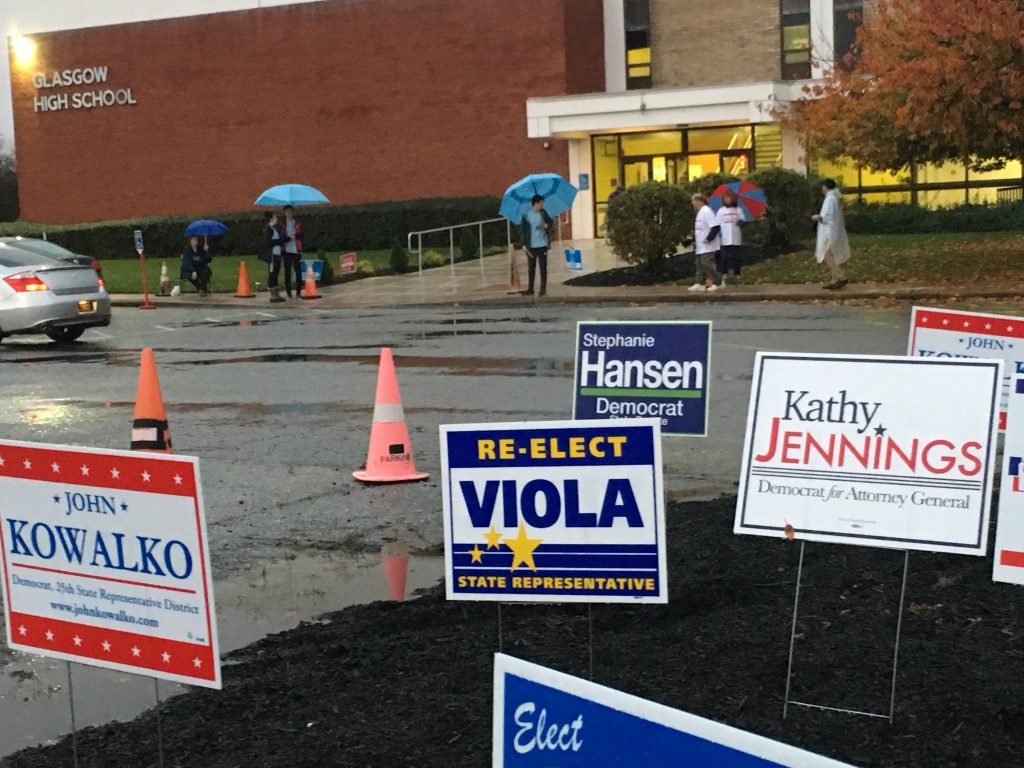 Delaware votes Poll workers carry umbrellas as they greet voters headed in to a polling place at Glasgow High School on Tuesday, Nov. 6. (Mark Eichmann/WHYY)