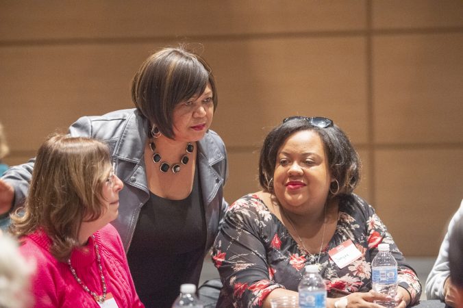 Sandra Clark talks with community members prior to the beginning of table discussions. (Jonathan Wilson for WHYY)