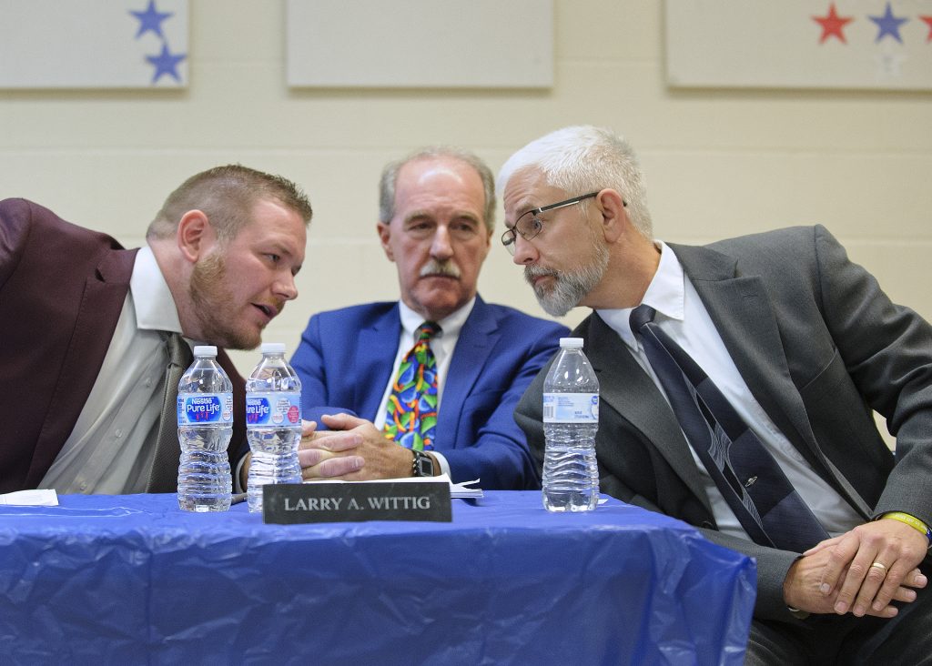 Tamaqua Area School District meeting regarding arming of teachers and staff Joe Egan, right, a representative of The Buckeye Firearm Foundation, at a Tamaqua School Board meeting in November 2018. Board member Nicholas Boyle, left, and School Board President Larry Wittig, confer with him. (Matt Smith for Keystone Crossroads)