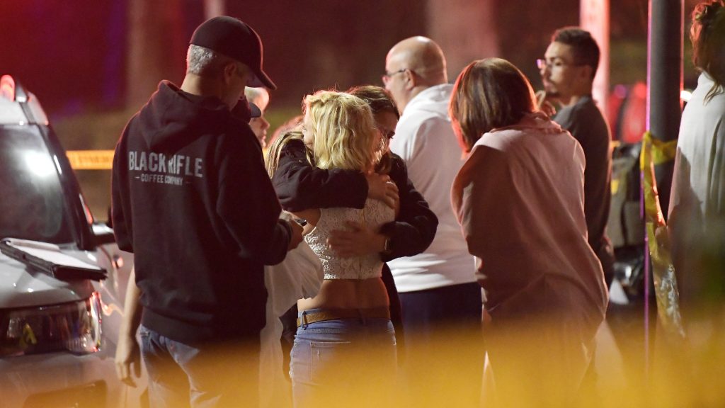 People comfort each other outside a bar in Thousand Oaks, Calif., where a gunman opened fire and killed 12. People comfort each other outside a bar in Thousand Oaks, Calif., where a gunman opened fire and killed 12.