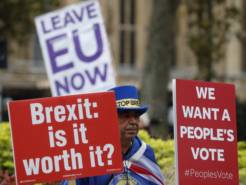 Demonstrators hold placards in London on Friday. Demonstrators hold placards in London on Friday. (Alastair Grant/AP)