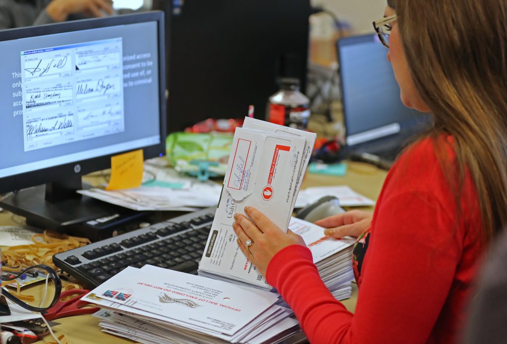 A Utah County election worker verifies signatures on mail-in ballots for the midterm elections on Nov. 6. A Utah County election worker verifies signatures on mail-in ballots for the midterm elections on Nov. 6. (George Frey/Getty Images)