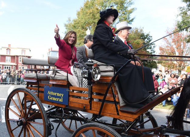 Kathy Jennings waves to the Return Day crowd in 2018, two days after being elected attorney general, while riding in a horse-drawn carriage from  Marvel Carriage Museum. (WHYY file)