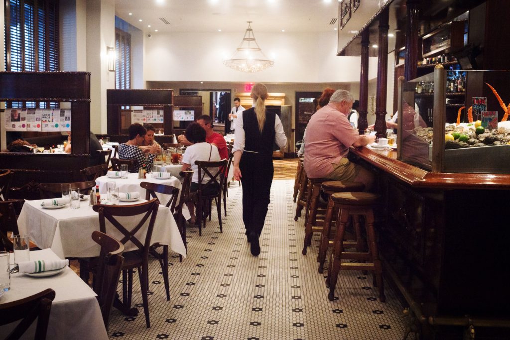 A member of the staff walks through Luke, one of the restaurants still owned by John Besh, on St. Charles Avenue in New Orleans. A member of the staff walks through Luke, one of the restaurants still owned by John Besh, on St. Charles Avenue in New Orleans. (Emily Kask for NPR)