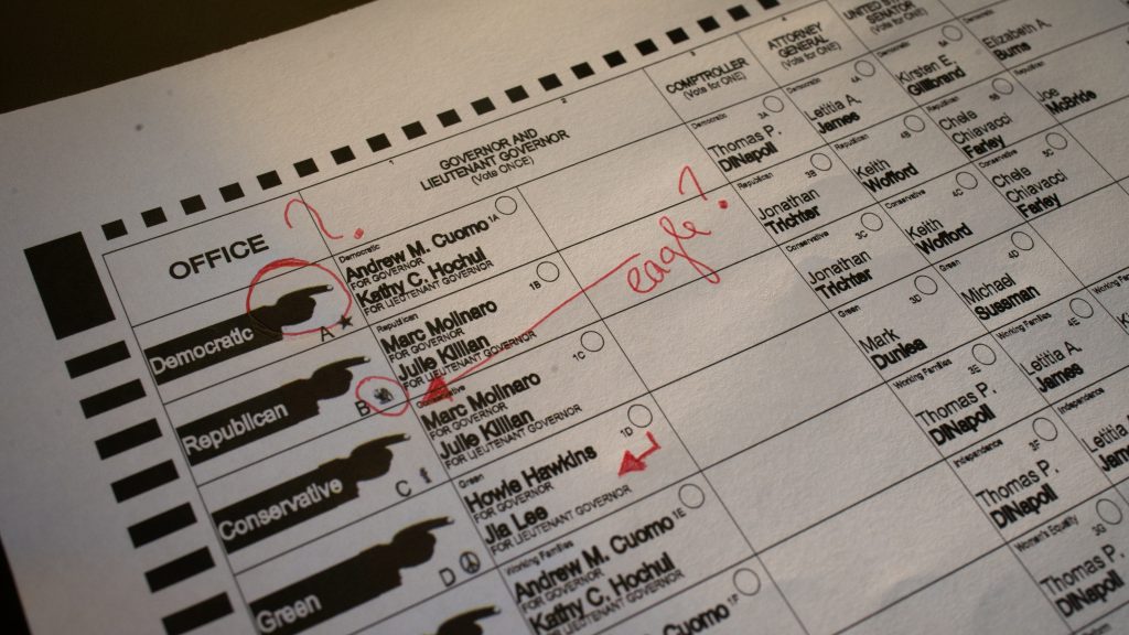 On a marked-up 2018 sample ballot from Chenango County, N.Y., illustrated index fingers point toward each candidate and tiny unfamiliar emblems represent each party — an eagle for Republicans, for example. One design expert calls these elements seriously antiquated. On a marked-up 2018 sample ballot from Chenango County, N.Y., illustrated index fingers point toward each candidate and tiny unfamiliar emblems represent each party — an eagle for Republicans, for example. One design expert calls these elements seriously antiquated. (Cameron Pollack/NPR)