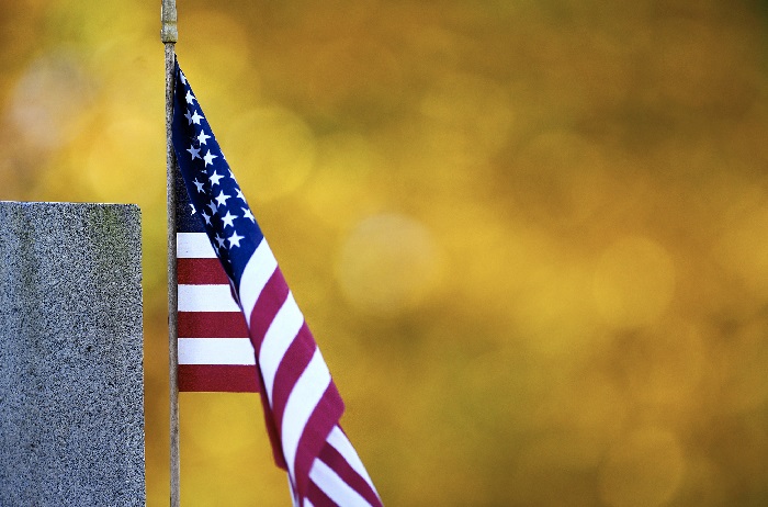 Veterans Day Antietam Cemetery An American flag blows in the wind surrounded by the color of autumn leaves at Antietam National Cemetery in Sharpsburg, Md., Thursday, November 8, 2018. November 11, 2018 is Veterans Day and marks 100 years since the end of World War I. (Colleen McGrath/The Herald-Mail via AP)