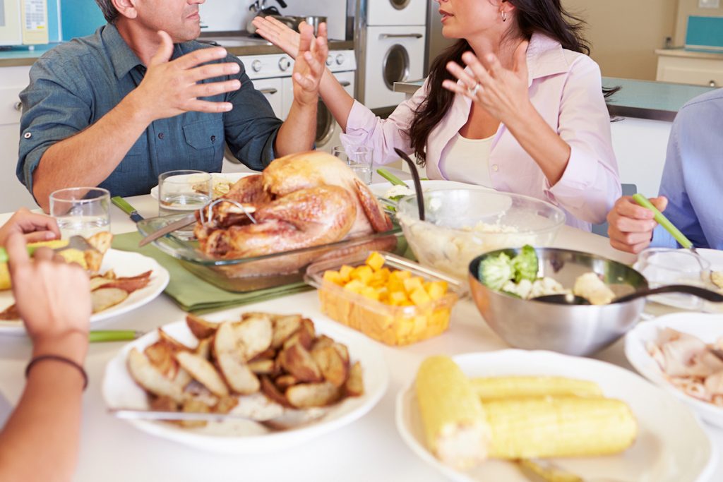 Family Having Argument Sitting Around Table Eating Meal