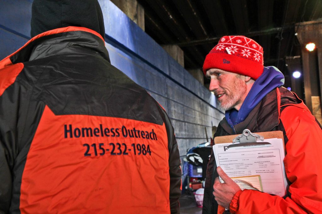 2017 12 29-k paynter-philadelphia-homeless outreach Luke Dunn talks to a homeless man and takes down his contact to make sure he gets entered into the homeless database, and promises to return for a referral for an I.D.