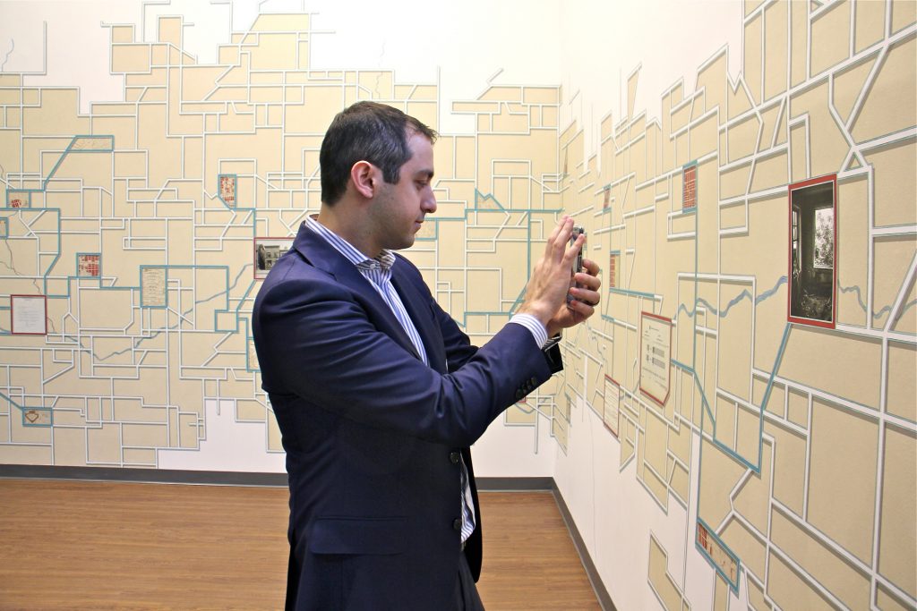 A visitor to Philadelphia City Archives uses his phone to interact with Talia Greene's vast mural, 