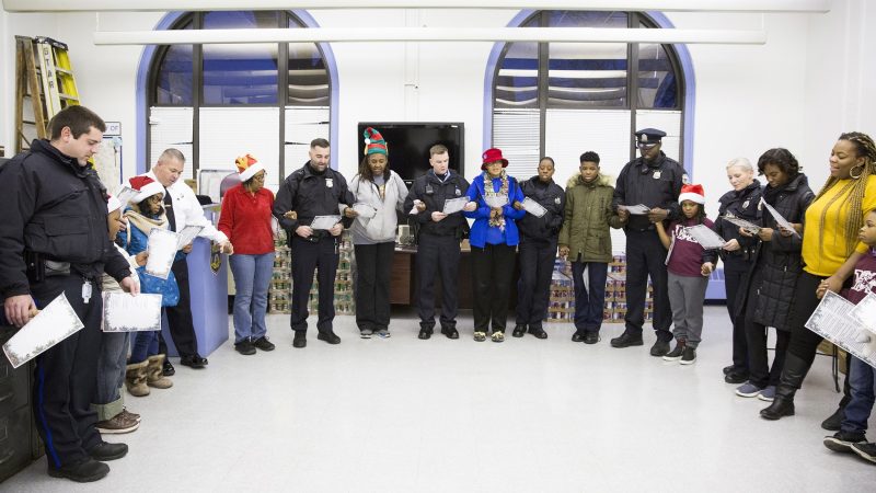 Philadelphia police officers and Hunting Park community members join hands to sing 