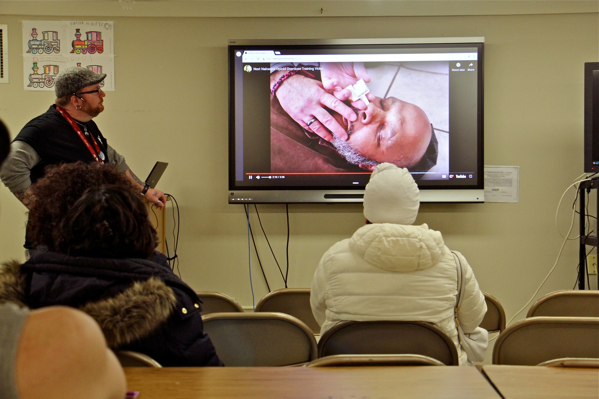 In the basement of Holmsburg Library, visitors watch a brief instructional video before receiving free naloxone, a drug administered nasally that reverses opioid overdoses.