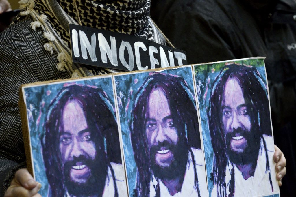 Free Mumia Rally in Philadelphia, PA A group of two dozen activists briefly block traffic during a rally outside the Philadelphia District Attorney’s office in December, 2018. The group called on DA Larry Krasner to not challenge a Common Pleas court ruling that allows Mumia Abu-Jamal to file an appeal. (Bastiaan Slabbers for WHYY)
